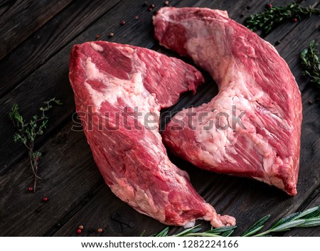 raw beef tri-tip steak for BBQ on wooden background, top view