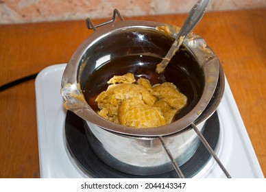 Raw Beeswax For Making Candles. Homemade Candle Making. Wax In The Process Of Melting In A Metal Dish On An Electric Stove. 