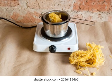 Raw Beeswax For Making Large Candles. Homemade Candle Making.Beeswax In The Process Of Melting Into A Liquid, In A Metal Bowl On The Electric Stove .