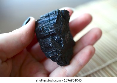 Raw Black Tourmaline Specimen. Schorl being held in hand. Black healing crystal. Ground and protective healing stone. Rough Schorl in woman's hand. Wiccan healing crystals
