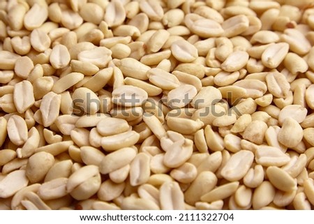 Raw blanched peanuts as food background closeup