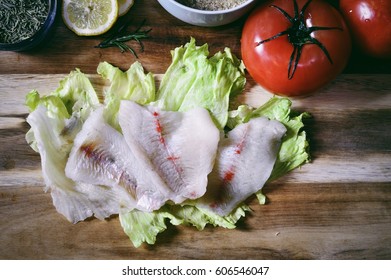 Raw Bluegill Fillets With Fresh Tomatoes, Lettuce And Lemons