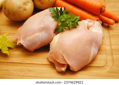 Raw Boneless Chicken Thighs on a Wooden Cutting Board	 - Powered by Shutterstock