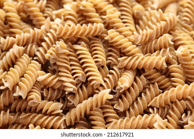 Raw Brown Pasta (Fusilli) Background. Close-up. 