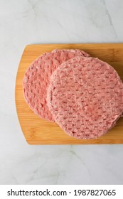 Raw Burger Meat, Over A Wood Plate And Herbs