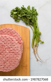 Raw Burger Meat, Over A Wood Plate And Herbs