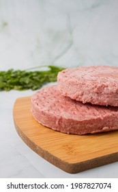 Raw Burger Meat, Over A Wood Plate And Herbs