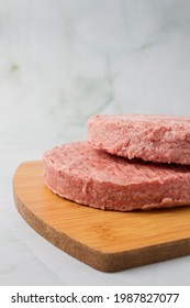 Raw Burger Meat, Over A Wood Plate And Herbs