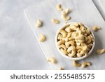 Raw cashew nuts in bowl or burlap sack on rustic table Healthy vegetarian snack, Anacardium occidentale