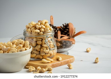 Raw cashews nuts in an open glass jar on marble background