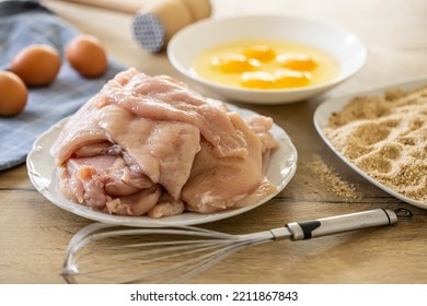 Raw Chicken Breasts, Bread Crumbs And Eggs With Whisker Ready For Making Schnitzels. 