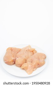 Raw Chicken Breasts On The Plate Above White Background.