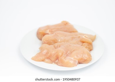 Raw Chicken Breasts On The Plate Above White Background.