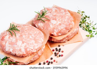 Raw Chicken Burger On A White Plate In A Rosemary Branch And Spices. Instant Meat. Grilled Hamburgers.Raw Hamburger, Meatballs On White Background.Fast Food At Home.Convenience Food, Precooked.