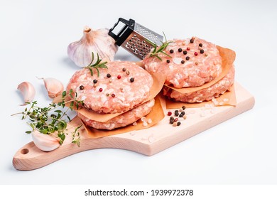 Raw Chicken Burger On A White Plate In A Rosemary Branch And Spices. Instant Meat. Grilled Hamburgers.Raw Hamburger, Meatballs On White Background.Fast Food At Home.Convenience Food, Precooked.