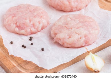 Raw Chicken Cutlets On Parchment Paper. Wooden Background. 