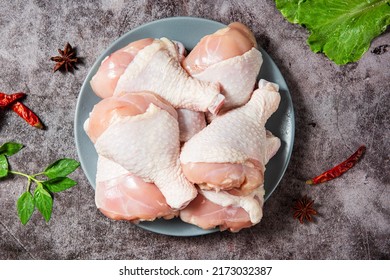 Raw chicken drumsticks with seasonings on table
