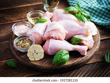 Raw chicken drumsticks with spices. Raw chicken legs with spices on a wooden background.