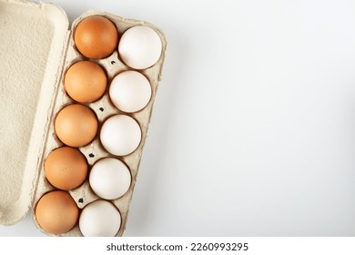 Raw chicken eggs in an egg tray on a white background. Space for text.