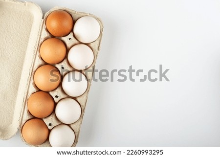Raw chicken eggs in an egg tray on a white background. Space for text.