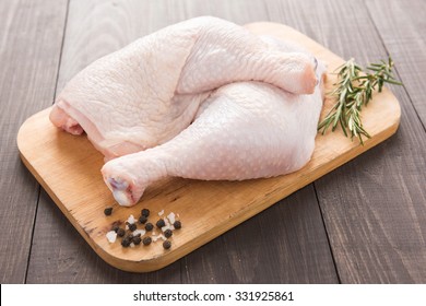 Raw Chicken Leg On Cutting Board On Wood Table.