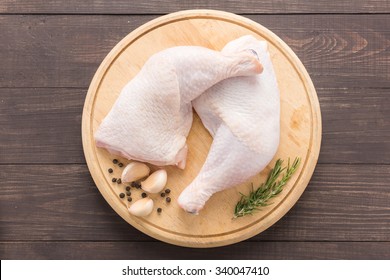 Raw Chicken Leg On Cutting Board On Wooden Background.