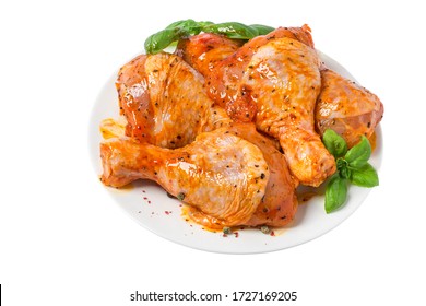 Raw chicken marinated drumstick or legs in a plate with herbs and spices isolated on white background. close up