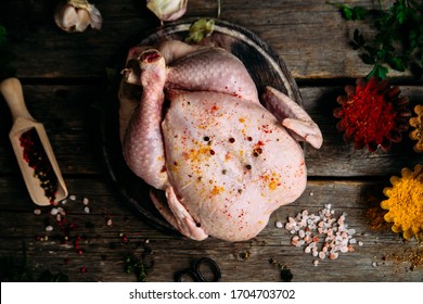 Raw chicken on a wooden table with spices