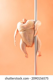 Raw Chicken performs a pole dance with an orange background. Minimal layout
