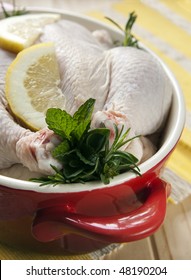 Raw Chicken In A Red Crock Pot, Stuffed With Fresh Herbs And Lemon, Ready For Cooking.