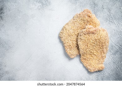 Raw chicken schnitzel Escalope in breadcrumbs. White background. Top view. Copy space