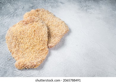Raw chicken schnitzel Escalope in breadcrumbs. White background. Top view. Copy space.