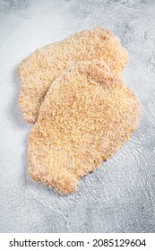 Raw chicken schnitzel Escalope in breadcrumbs. White background. Top view