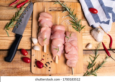 Raw chicken skewers with . Kebab. On a wooden background. Top view. Healthy chicken breast fillets packed with protein.Raw chicken skewers of tender chicken fillet on skewers.