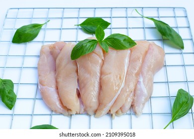 Raw Chicken Tenders With Basil Leaves