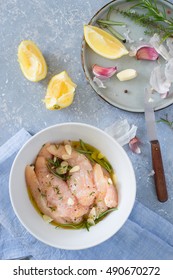 Raw Chicken Tenders Marinated With Garlic, Olive Oil, Lemon Juice, Rosemary, Thyme, Salt And Pepper