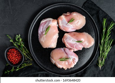 Raw Chicken Thigh Fillet Without Skin. Farm Poultry Meat. Black Background. Top View