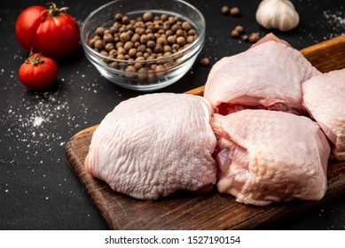 Raw Chicken Thigh On Black Background.