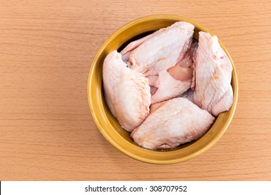 Raw Chicken Wings In Bowl On Wooden Table With Copy Space.