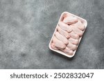 Raw chicken wings on tray, grey grunge background. Top view, flat lay, copy space