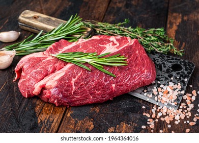 Raw Chuck Eye Roll Black Angus Prime Beef Steak On Butcher Cleaver. Dark Wooden Background. Top View