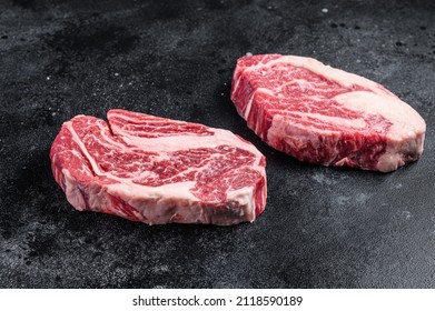 Raw Chuck Eye Roll Steaks, Premium Beef Meat On A Butcher Board. Black Background. Top View