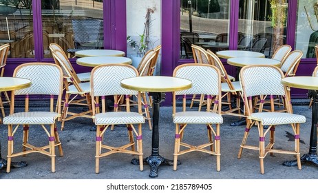 A Raw Of Classical Chairs In The Side Walk Next To A Cafe.