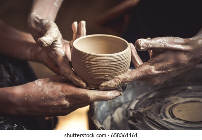 A raw clay pot in the hands of a potter. Workshop in the pottery workshop