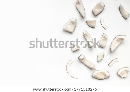 Raw coconut pieces on a white background with copyspace