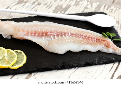 raw cod fillet over slate plate