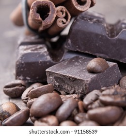 Raw Coffee Beans And Chocolate On Old Wooden Plank