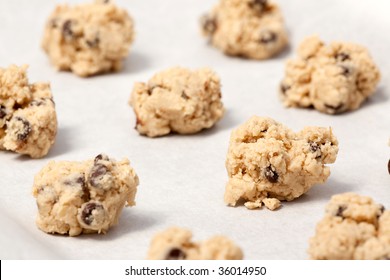 Raw Cookie Dough On A Baking Sheet With Parchment