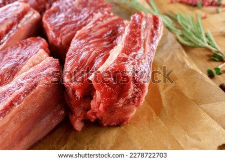 Raw cowboy steak on wooden background, prime rib eye on bone. Close up