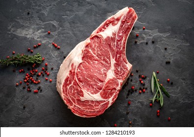 raw cowboy steak with seasonings on stone background, prime rib eye on bone, top view - Shutterstock ID 1284210193